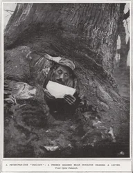 A Peter-Pan-like "dug-out", a French soldier near Monastir reading a letter