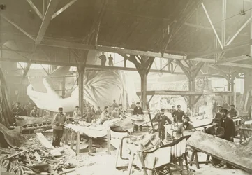 Men in a workshop hammering sheets of copper for the construction of the Statue of Liberty
