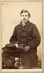 Unidentified man in overcoat with hat and gloves