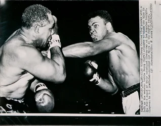 Young Cassius Clay scores with a left against the veteran Archie Moore in the first round of the fight in Los Angeles