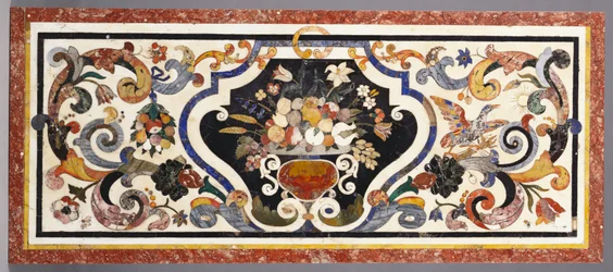A Florentine pietra dura table top centred by a bowl of fruit and flowers
