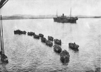 Australian Troops Being Towed Ashore in Lighters to Land at Anzac Cove, Gallipoli. In the Background is the Transport Ship, 1915