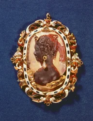 Cameo bearing the profile head of the goddess Diana, with a drop-pearl earring, the gilt frame decorated with semi-precious stones and white and blue enamel
