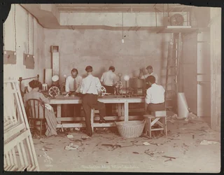 Film laboratories at Carlton Motion Picture Co. with five men and one woman working with film, splicing etc., New York