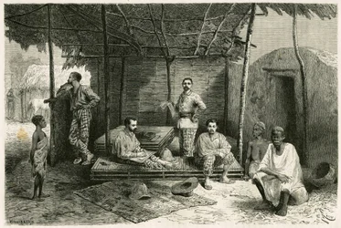 Installation of the mission in Nango, for a 10-month stay, with portraits of Gallieni and his captains Vallière and Pietri, Doctor Tautain as well as his interpreters, guide and cantinière. Engraving by Riou, based on a sketch by the author, to illustrate 