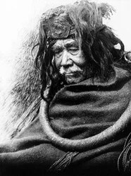 The Hamatsa, Nakoaktok c. 1910 Half-length portrait of Nakoaktok man, facing left, wearing cedar root ceremonial loop.