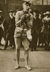 An actor dressed up as Houdini outside a theatre pit-door