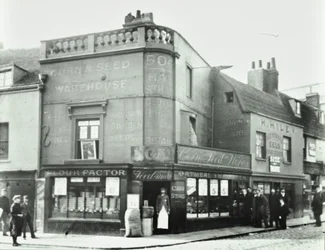 Deptford Broadway: street scene with shop fronts, London, 1897