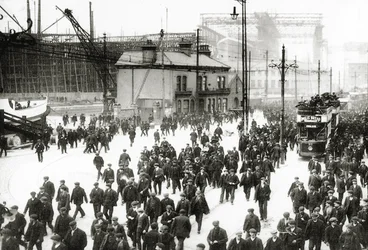 Knocking-off time at the Harland and Wolff shipyard, Belfast, Ireland with the Titanic under construction in the background, 1910-11