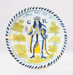 A Bristol Delft polychrome royal portrait charger painted with a full length portrait of George I in formal robes, c.1720