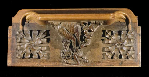 A misericord depicting a small capped figure pounced on by a monster, New College Chapel, Oxford, late 14th century