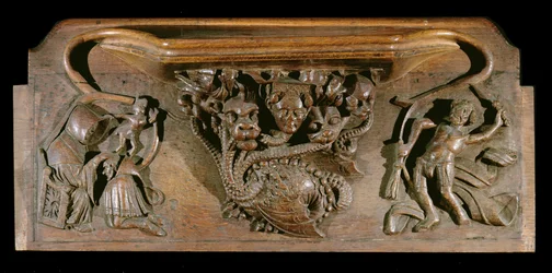 A misericord depicting an elaborately carved hydra, symbolic of the seven deadly sins, incorporating a realistic human head, New College Chapel, Oxford, late 14th century