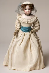 Bisque fashion doll with swivel head, wearing a long cream dress and hat