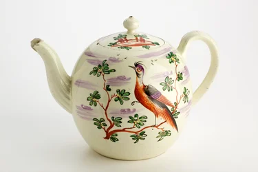 Staffordshire teapot decorated with exotic bird and building among trees, c.1765-75