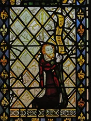 Window depicting quarries and a border of fleurs de lis and lions surround the donor