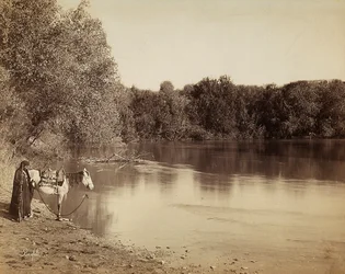 A Man in Traditional Dress with His Horse, in Front of a Lake in Egypt