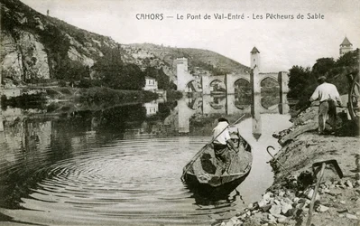 Cahors at the beginning of the 20th century: sand fishermen and their boat on the Lot, bridge of Valentre