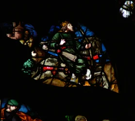The west rose window depicting a scene from the Book of Revelation: A man on a white horse with a bow, arrows and a crown