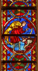 Window w213 depicting a scene from the life of St Thomas: a lion attacks the cupbearer as he collects water and removes his arm