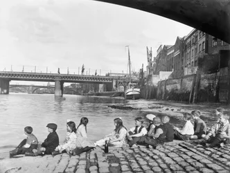 Children on the cobbled causeway under Southwark Bridge, London, c1930