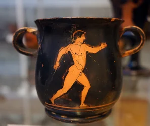 Ancient Greek red-on-black mug depicting an athlete