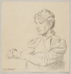 Portrait of a young girl with her hands on the table, shown to the waist