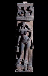 Hinduism: representation of a Yakshini (Yaksi) spirit of nature, holding a cage and a parrot, standing on a dwarf - Mathura sculpture, sandstone, 2nd century