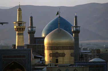 The all-gold dome and minaret of the shrine of Imam Reza, with the Timurid Gowhar Shad Mosque behind