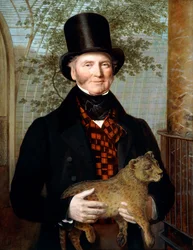 Portrait of Edward Cross, half-length, in a black coat and red-check waistcoat, holding a lion cub