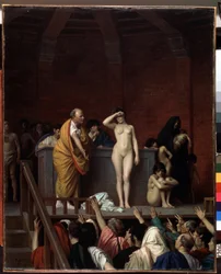 Ancient Rome: “The Slave Market in Rome”. A nude female slave is sold on a platform before an audience of buyers raising their arms to make an offer. Painting by Jean Léon Gérôme (1824-1904), 1884. Dimensions 92 x 74 cm. Musée d