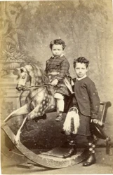 Young Girl on Rocking Horse with Young Boy in Kilt Standing, 1860s