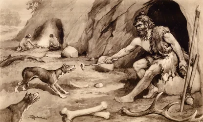 Cave man feeding dog