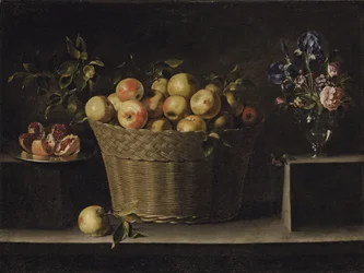 Apples in a wicker basket, a pomegranate on a silver plate and flowers in a glass vase