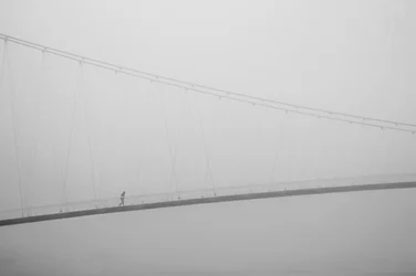 Solitary Walk on Foggy Bridge