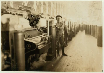 Boy sweeper by carding machines at Lincoln Cotton Mills, Evansville, Indiana in stockinged feet on a slippery floor, 1908