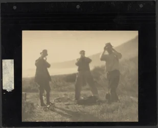 [Three Men Standing on Hillside with Hands before Their Faces]
