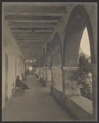 Woman Sitting in a Mission Hallway