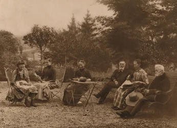 A group of men and women sat talking by a table