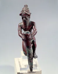 Copper foundation figure depicting a god pushing a nail
