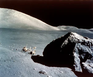The Rover is dwarfed by a giant rock on the lunar surface, Apollo 17 mission