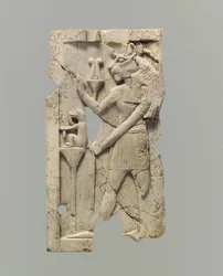 Furniture plaque carved in relief with lion-headed figure