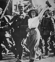 WWI German Troops Marching Off to War, Their Tunics & Rifles Festooned with Flowers from the Jubilant Crowd