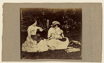 [Child asleep with two women seated on grass]