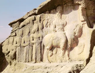 Rock relief depicting Shapur I and his family wearing heraldic emblems on their hats