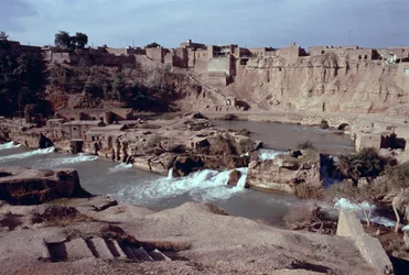Remains of the Sika bridge-dam-waterway complex on the Gar-Gar River with the city of Shushtar in the background
