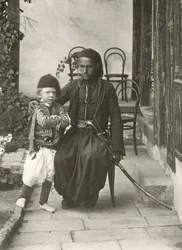 Arab kawass (Ottoman guard) with a young boy in the garden of a house in the Judea District of Jerusalem