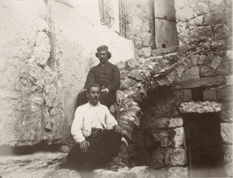 Two men sitting next to the lintel of Barclay