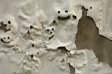 Smiley ghost faces on weathered painted wall, 2022 (photo)