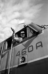 Engineer of the Great Northern Railroad waves from the cab of an EMD E7 locomotive