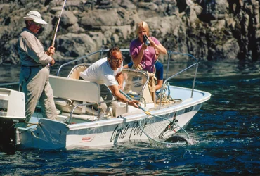 An angler reels in a salmon at Bute Inlet